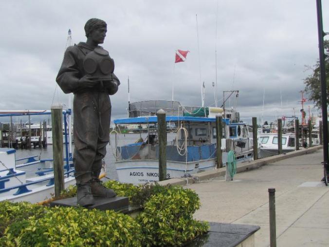 Statue honoring the Greek sponge divers. That is a real sponge boat tied to the dock.